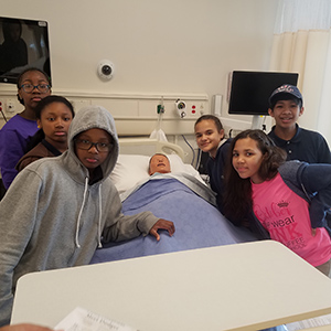 Six graders at Paul Cuffee school view a mock hospital room